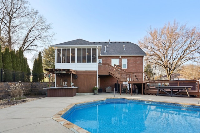 back of house with a bar, a pool side deck, and a sunroom