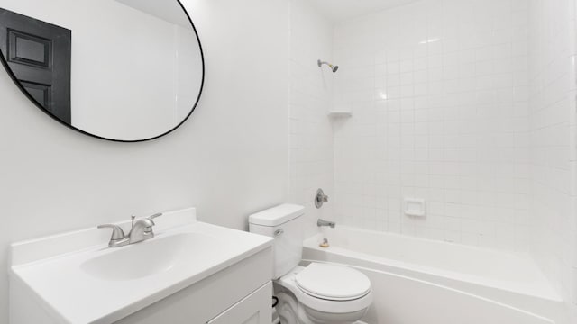 full bathroom featuring tiled shower / bath, vanity, and toilet