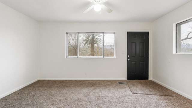 carpeted entrance foyer featuring a wealth of natural light and ceiling fan