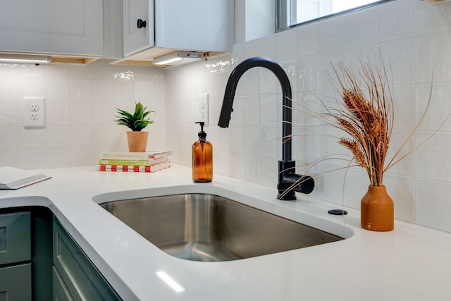 interior details featuring tasteful backsplash, sink, and green cabinetry