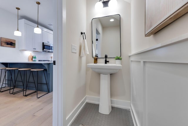 bathroom with sink, hardwood / wood-style floors, and backsplash