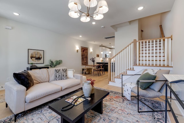 living room with a notable chandelier and light hardwood / wood-style floors