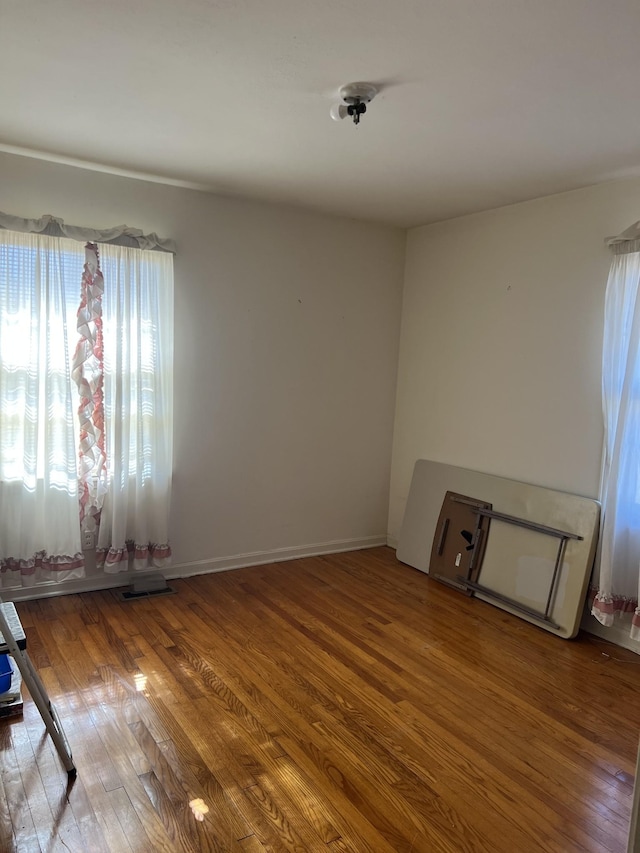 unfurnished room with wood-type flooring