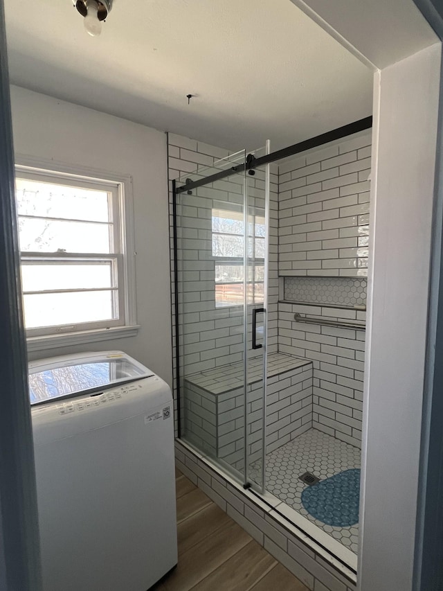 bathroom featuring hardwood / wood-style flooring, plenty of natural light, and a shower with door