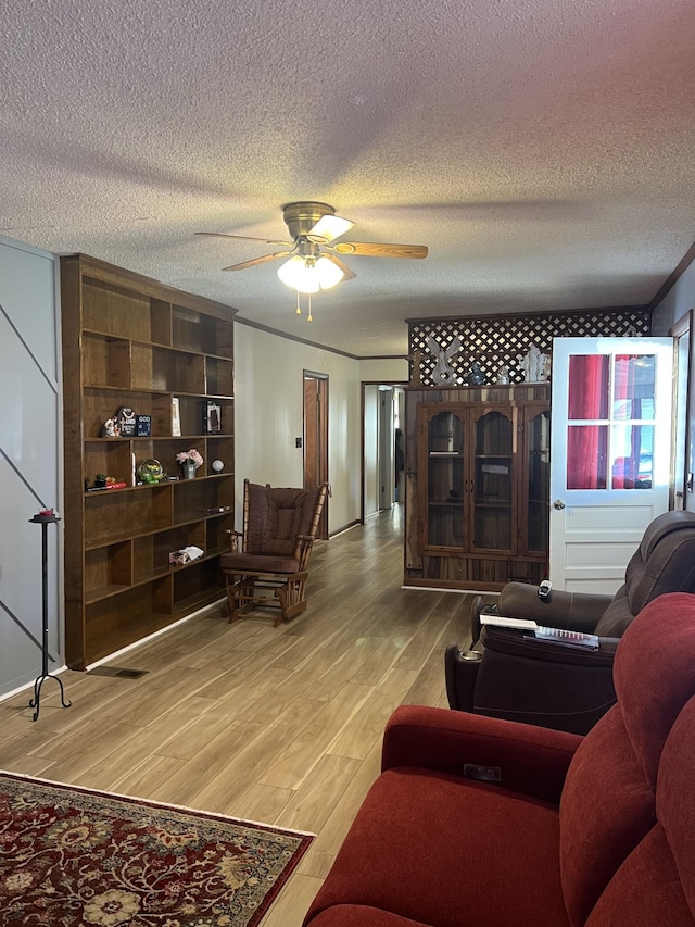 living room featuring hardwood / wood-style floors, a textured ceiling, and ceiling fan