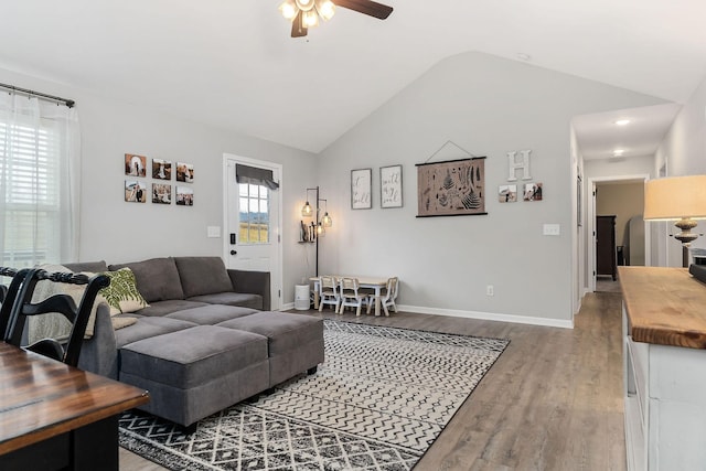 living room with wood-type flooring, lofted ceiling, and ceiling fan