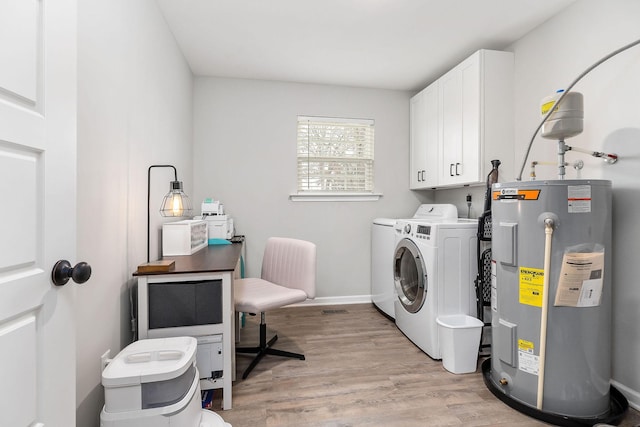 washroom featuring washer and dryer, electric water heater, cabinets, and light wood-type flooring