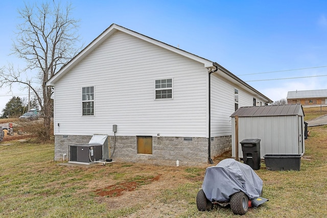 view of side of property featuring cooling unit, a shed, and a lawn