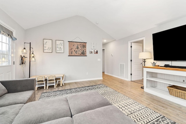 living room with hardwood / wood-style flooring and vaulted ceiling