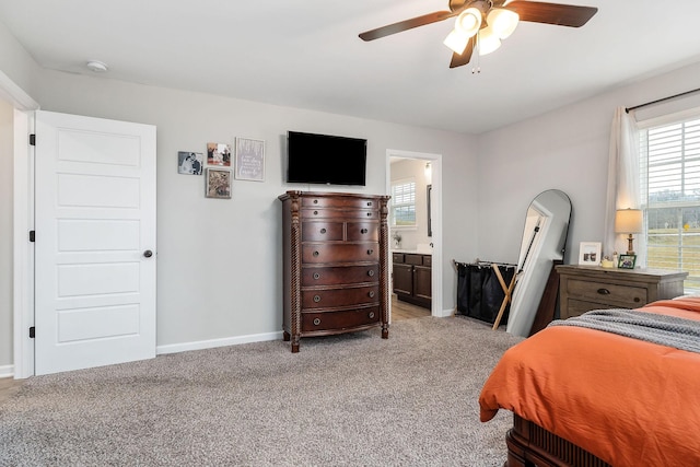 bedroom featuring ceiling fan, connected bathroom, and light colored carpet