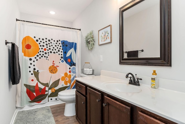 bathroom featuring vanity, hardwood / wood-style flooring, and toilet