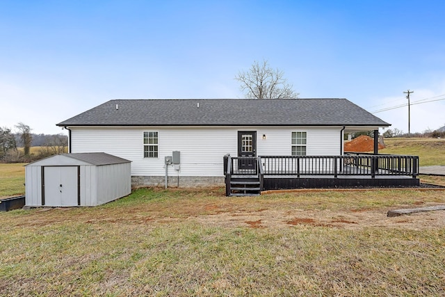 back of property featuring a wooden deck, a storage unit, and a lawn