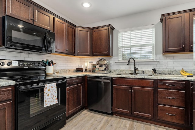 kitchen featuring dark brown cabinetry, sink, light hardwood / wood-style flooring, decorative backsplash, and black appliances