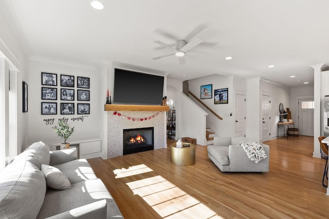 living room with hardwood / wood-style flooring, crown molding, and ceiling fan