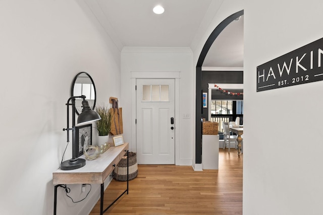 entrance foyer with crown molding and wood-type flooring