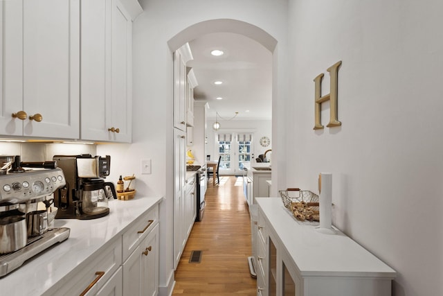 kitchen with sink, light wood-type flooring, and white cabinets