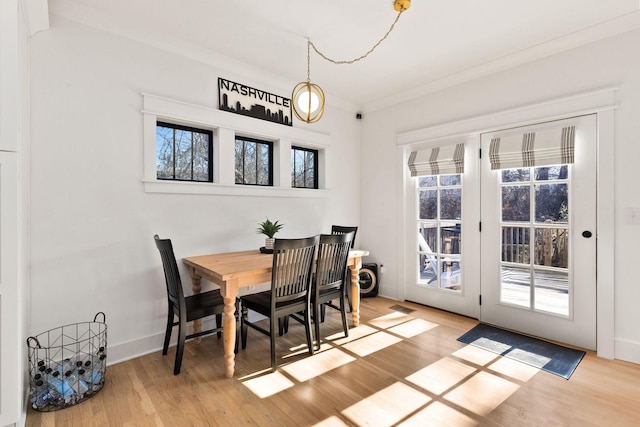 dining room featuring ornamental molding and light wood-type flooring