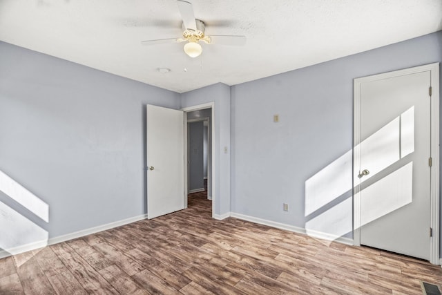 unfurnished bedroom featuring hardwood / wood-style floors and ceiling fan