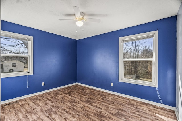 unfurnished room featuring hardwood / wood-style flooring, ceiling fan, and a textured ceiling