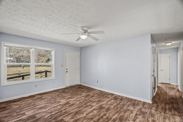 spare room with ceiling fan, dark hardwood / wood-style floors, and a textured ceiling