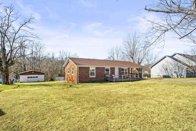 single story home with a garage, an outbuilding, and a front lawn