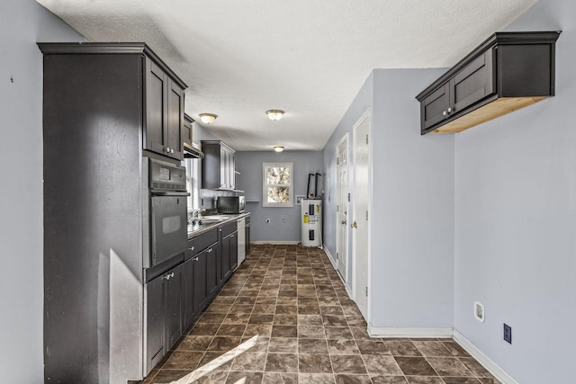 kitchen with dark brown cabinetry, sink, black oven, and electric water heater