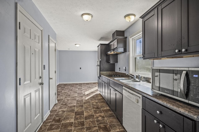 kitchen featuring stainless steel appliances, sink, and a textured ceiling