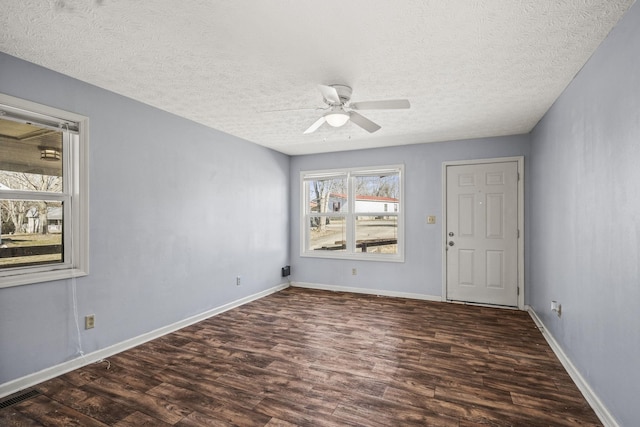 empty room with dark hardwood / wood-style flooring, ceiling fan, and a textured ceiling