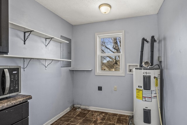 laundry area with hookup for a washing machine, electric water heater, and a textured ceiling