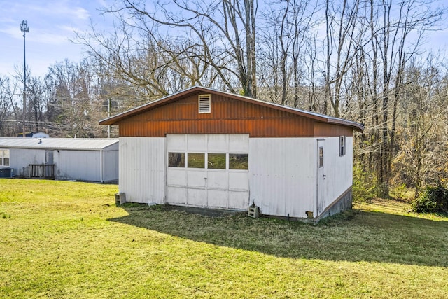 garage with a lawn and central air condition unit