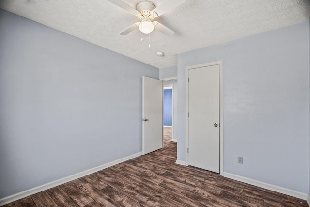 unfurnished bedroom featuring dark wood-type flooring, a textured ceiling, and ceiling fan