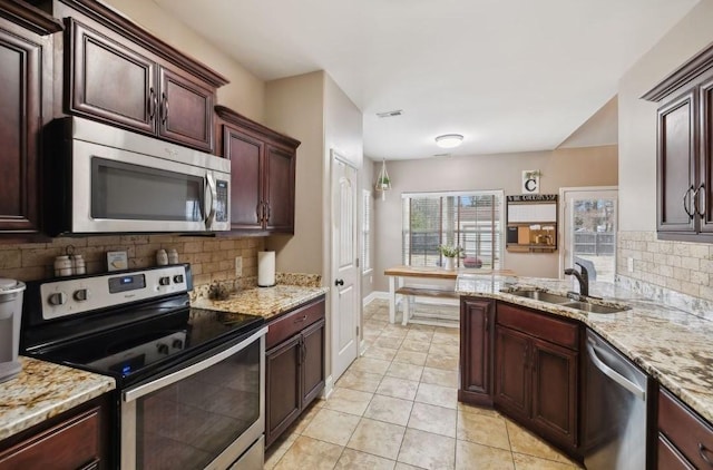 kitchen featuring appliances with stainless steel finishes, sink, decorative backsplash, and light tile patterned floors