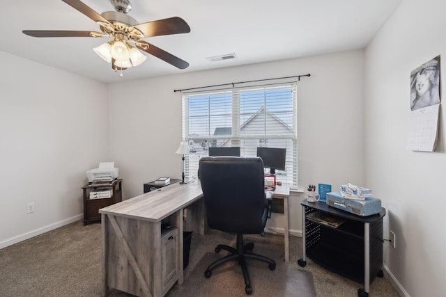 carpeted home office with a wealth of natural light and ceiling fan