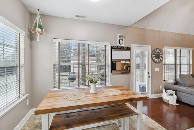 tiled dining space featuring plenty of natural light