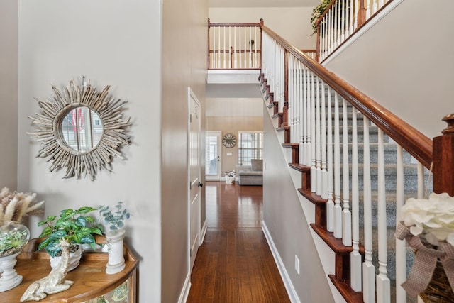 staircase featuring a high ceiling and hardwood / wood-style floors