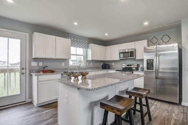 kitchen featuring white cabinetry, a kitchen island, dark hardwood / wood-style floors, and appliances with stainless steel finishes