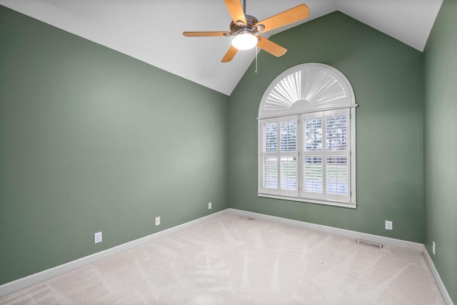 spare room featuring lofted ceiling, ceiling fan, and carpet flooring