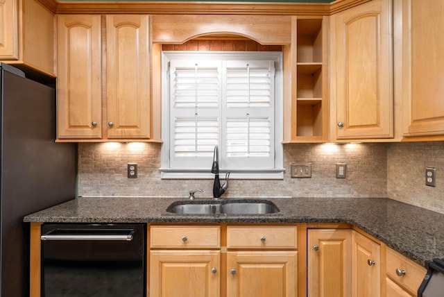 kitchen with sink, dark stone countertops, stainless steel refrigerator, black dishwasher, and backsplash