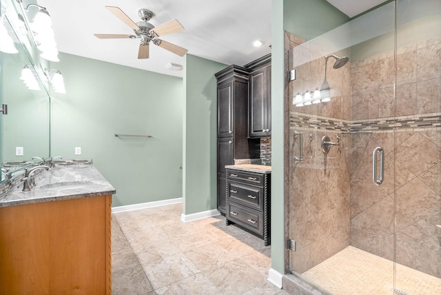 bathroom with ceiling fan, vanity, and a shower with door