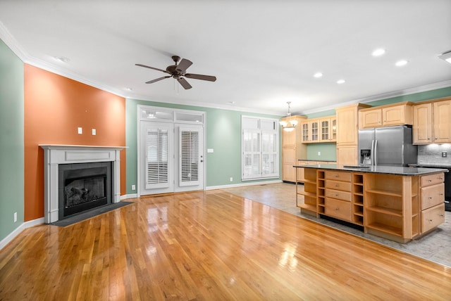 kitchen featuring decorative light fixtures, dark stone counters, a center island, light hardwood / wood-style floors, and stainless steel refrigerator with ice dispenser