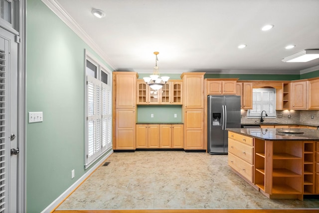 kitchen with stainless steel refrigerator with ice dispenser, light brown cabinetry, sink, and pendant lighting