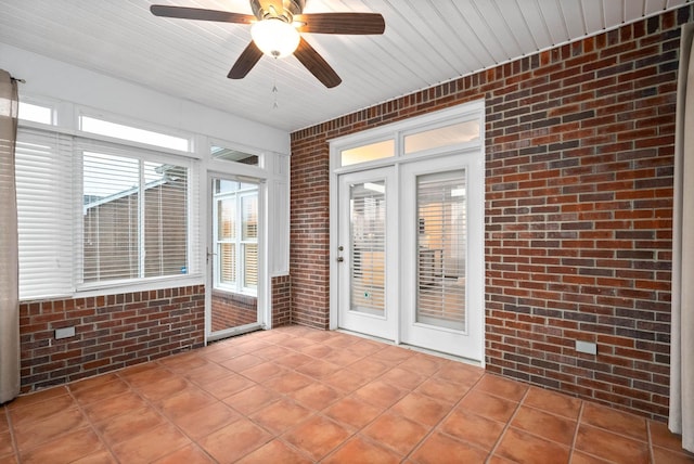 unfurnished sunroom featuring ceiling fan