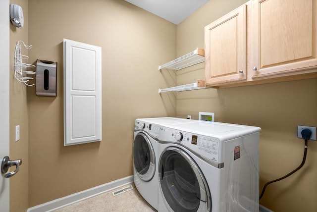 washroom with cabinets and washing machine and dryer