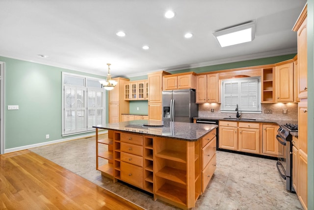 kitchen featuring sink, tasteful backsplash, a center island, dark stone countertops, and stainless steel appliances