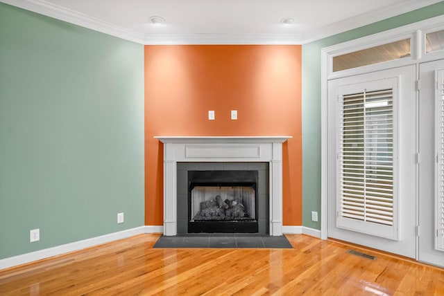 room details with crown molding, hardwood / wood-style floors, and a fireplace