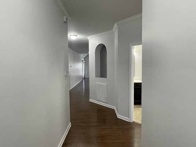 hall featuring ornamental molding and dark wood-type flooring