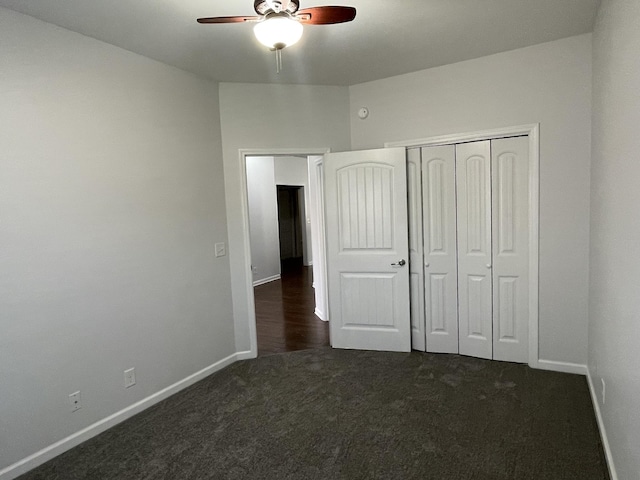 unfurnished bedroom featuring dark colored carpet, ceiling fan, and a closet