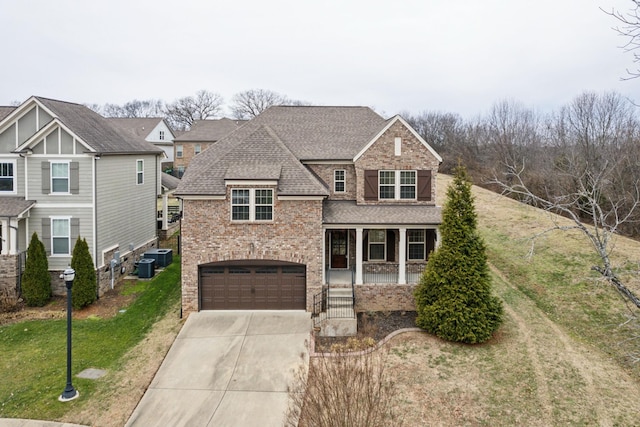 view of front of home with a garage, a porch, central AC, and a front yard