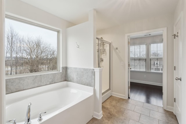 bathroom with tile patterned flooring and separate shower and tub