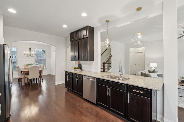 kitchen featuring sink, decorative backsplash, stainless steel appliances, and hanging light fixtures